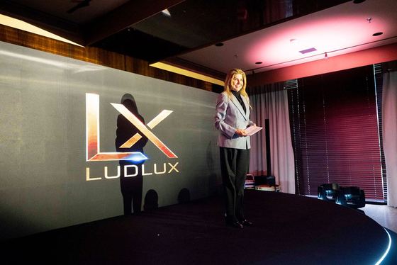 Apresentação no palco com a marca LudLux ao fundo